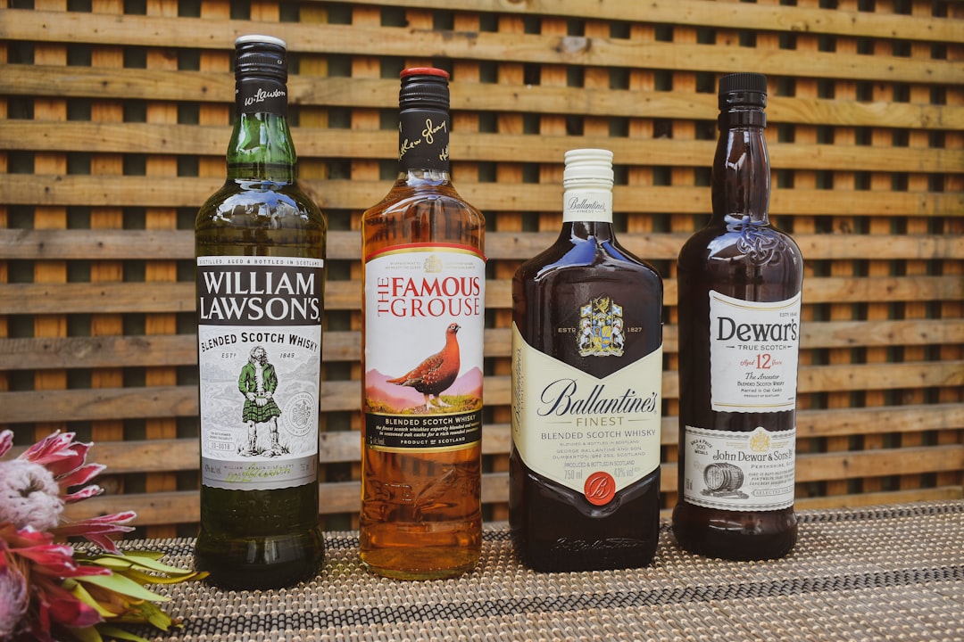 single malt whisky bottles lineup, scotch whisky glass amber color